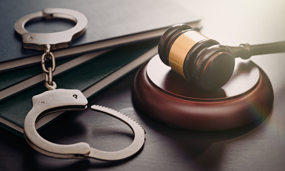 Image of a gavel and handcuffs on a desk
