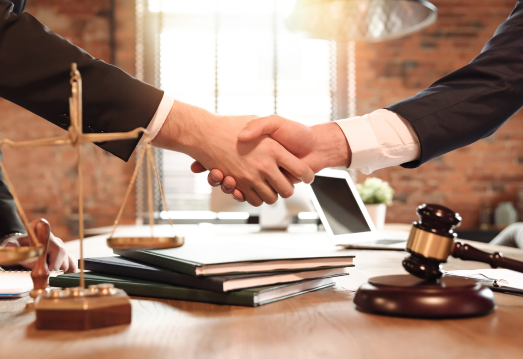 Image of an attorney shaking hands with a client over a desk