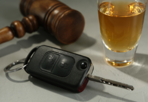 Image of a car key, a glass of beer and a gavel