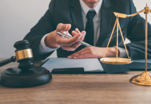 Image of a probate attorney sitting at a desk with a gavel, scale, and clipboard