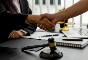Image of people shaking hands over a desk with a gavel